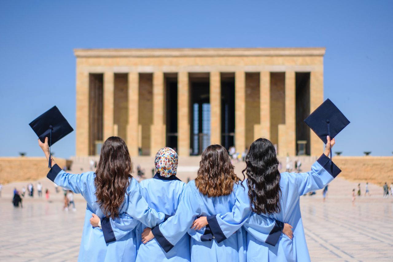 Crafting Captivating Headlines: Your awesome post title goes here Graduates in blue gowns celebrate in front of Anıtkabir, Ankara, symbolizing academic achievement.